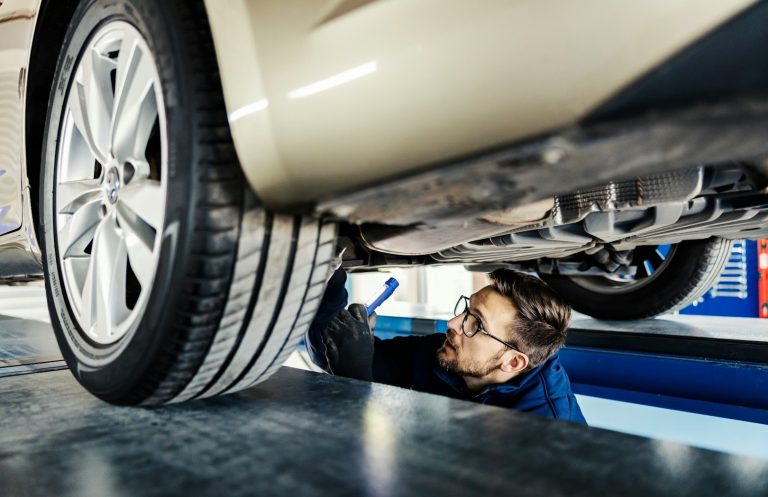 Mechaniker überprüft das Rad eines Autos in einer Werkstatt.